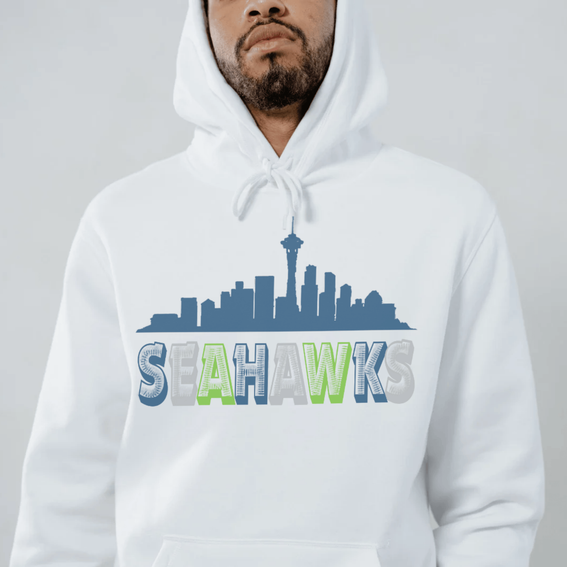 Person wearing a white hoodie with a 'Seahawks' design featuring a city skyline.